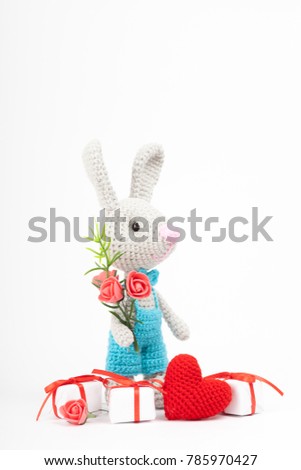knitted rabbit with a heart. St. Valentine's Day decor. Knitted toy, amigurumi. Valentines day greeting card.