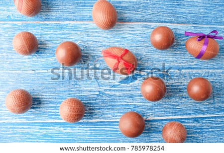 Chocolate Easter eggs and sweets on wooden background
