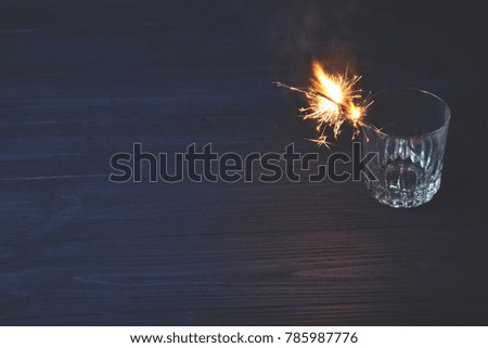 Sparkler in the glass. Holidays lights. New Year celebration. 
