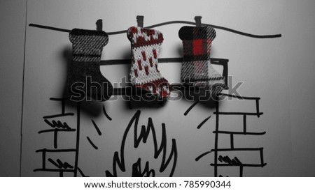 three socks hanging on drawn fireplace