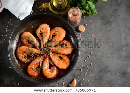 Roasted (fried) big shrimps in tomato sauce with olive oil, garlic, cilantro and soy sauce... Royalty-Free Stock Photo #786005971