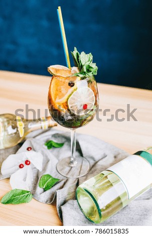 a glass of cold alcoholic cocktail mojito - sangria on a wooden table
