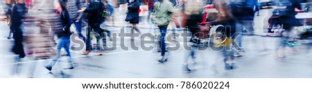 picture in motion blur of a wintry street scene in the city with people crossing a street