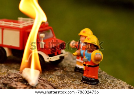 Firefighter toys with a fire truck extinguishing fire