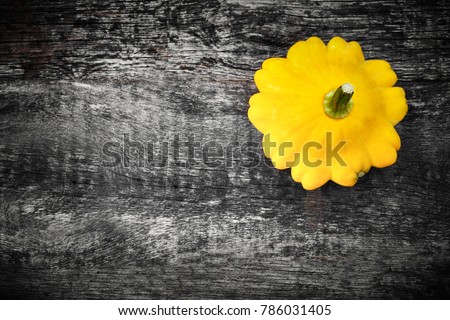 Colors of 2021. Illuminating Yellow squash on Ultimate Gray colored background. Fresh pattypan vegetable on old wooden board, top view