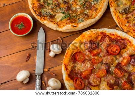 Hot fresh homemade pizza with natural toppings photographed on wooden table background