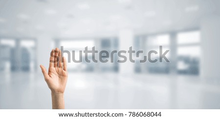 Close of woman hand touching screen with palm and office at background