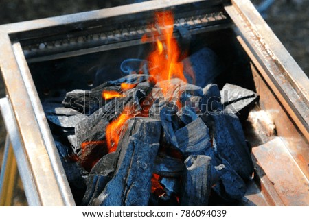 A barbecue charcoal flame to raise a flame