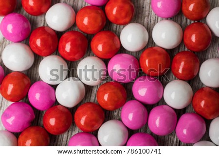Red white and pink candy arranged on a white painted board