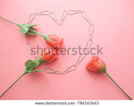 rose flowers with the heart shape from clip in the middle on the pink background, Concept for love in the valentine day.