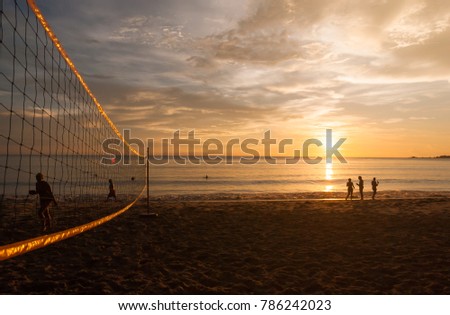 Natural lighting and shadow of blurred silhouette people is walking on beach to watche sunset on clouds and golden sky background with copy space. Travelling,chilling sunbathing concept.