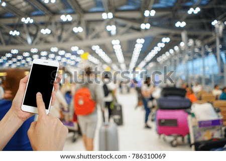Hand holding mobile phone with airport terminal blurred crowd of Travelling people on the background, Bokeh light, Social network, internet,Traveling concept