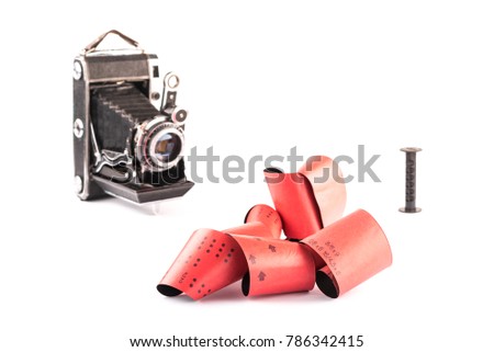 120 film for medium format retro cameras on white background with shadows, blurry vintage cameras with plastic spool on background, auctions, hobby and collections