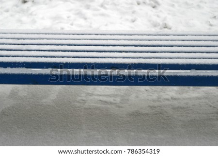 The benches in the park are covered with white snow. Winter holiday background
