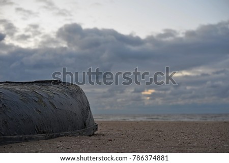 Small boats on the beach against the background of a cloudy sky