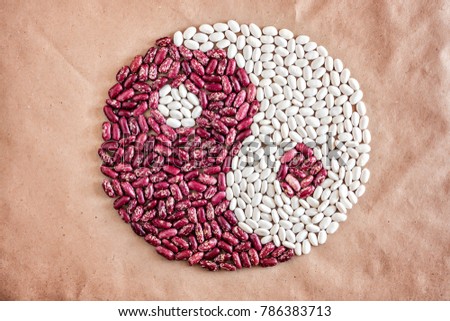 Yin Yan symbol of grain beans haricot red white on paper vegan concept background macro closeup