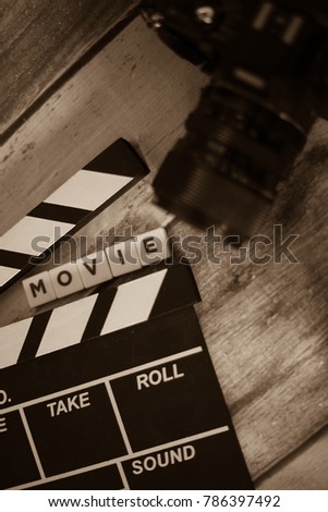 Movie clapper and old camera on a wooden background, movie shooting, film, screenplay, director