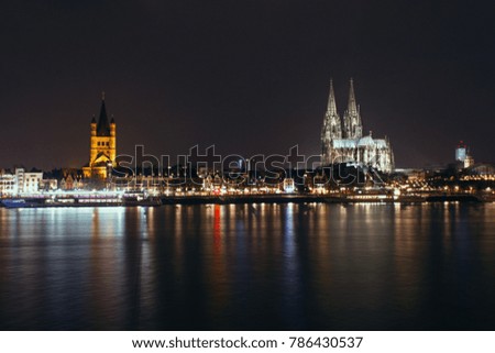 The night city is reflected in the river. Cologne. Germany