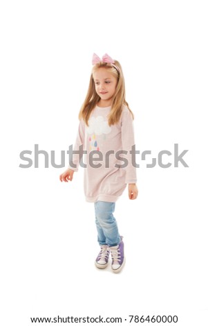 Full length of joyful little girl, dancing. Isolated on white background