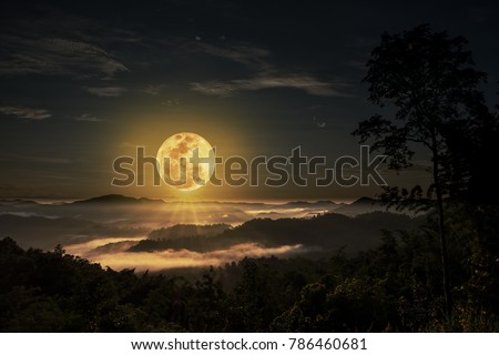 Big full moon beyond the valley which is the mist cover the mountain.