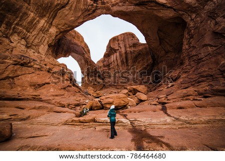 This is the picture of the traveler standing at Cove of Caves at Arches National Park in Winter at Utah.
