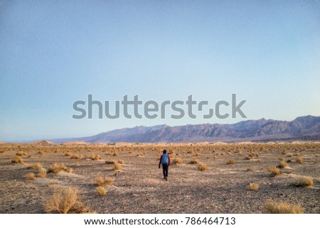 This is picture of a male hiker hiking at Mesquite Flat Sand Dunes during sunset at Death Valley National Park, California.
