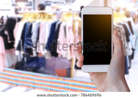 Woman use mobile phone, blur image of inside supermarket background,Shopping Purchase Order Concept.