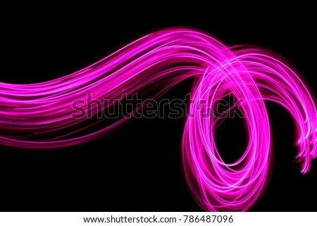 Pink light painting photography, long exposure, parallel lines of pink fairy lights in a stream of color, loops and swirls against a black background