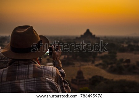 Photographer enjoying sunrise over the hystorical Angkor at Cambodia Royalty-Free Stock Photo #786495976