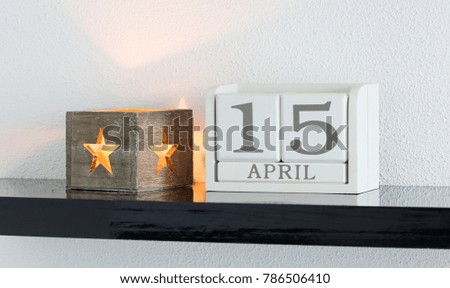White block calendar present date 15 and month April on white wall background