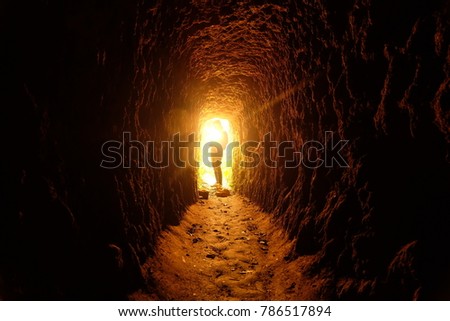 Light at the end of the tunnel. Tunnel to success. Girl inside an abandoned mine in Thailand.