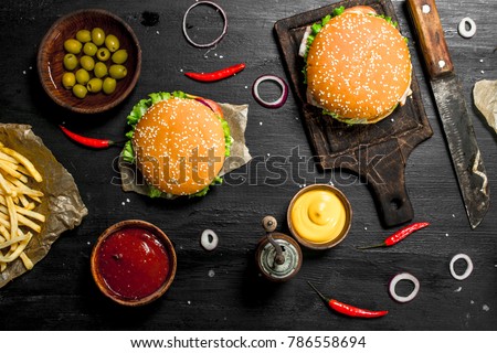 Street food. Fresh burgers with beef and vegetables. On the black chalkboard.