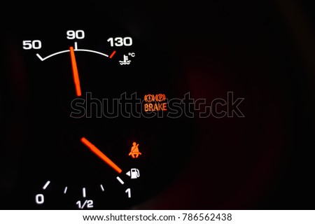 Part of automobile dashboard with parking brake, engine temperature and fuel level indicators