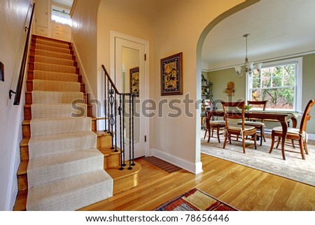 Hallway with large staircase and dining room