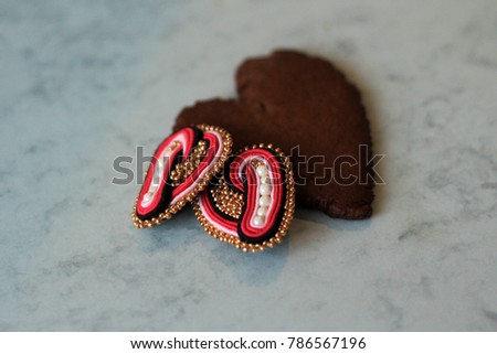 Two heart shaped decorations and a heart gingerbread cookie