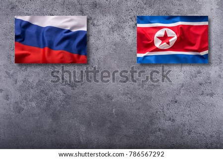 North Korea and Russia flag on concrete background.