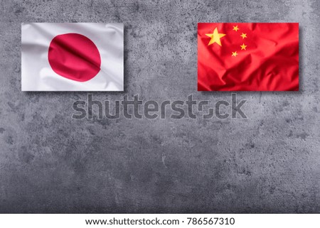 China and Japan flag on concrete background.