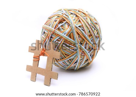 Hashtag made from cardboard with big colorful thread ball isolated on white background. Cotton thread ball made from different color (orange, yellow, green, blue) with hashtag sign  concept.