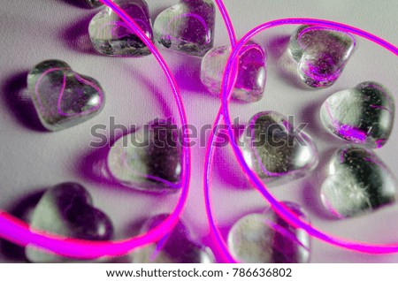 A Studio Photograph of Glass Hearts with Abstract Pink Neon Lighting