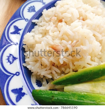 Rice cooked in chicken stock to eat with steamed chicken. Hainanese Chicken Rice or Khao Man Kai. Popular food in Thailand. (close up, square crop)