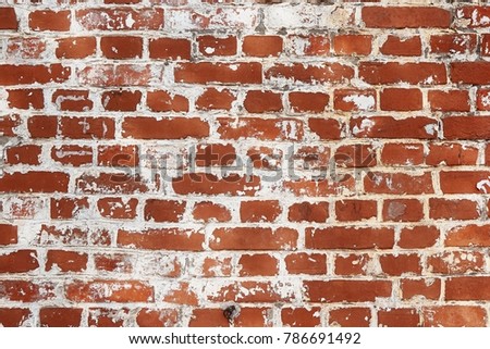 Old red brick wall texture. Abstract background of horizontal brickwork with flakes of exfoliated white paint. 