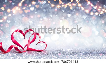 Valentines Card - Red Ribbon Shaped Hearts On Silver Shiny Background With Lights
