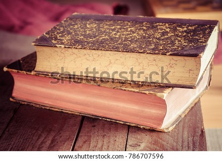 pile of old books on wooden brown table in bookstore (Shallow depth of field)