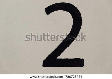 black number 2 on a light wall
