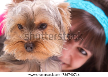 A puppy tolerates having it's picture taken as a happy girl holds it up to the camera