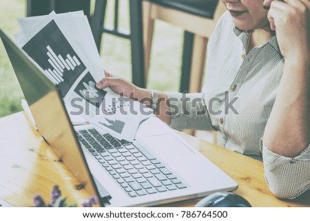 Close Up of woman hands using mobile phone and laptop computer with blank copy space screen for your advertising text message or content business at a coffee shop with a document.