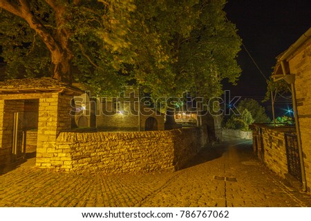 Traditional architectural buildings and narrow paved streets at the picturesque village of Papigo, Greece at night. Epirus, Greece, Europe.