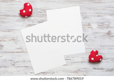 Hearts and sheet of blank paper on wooden table