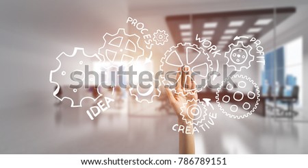 Close of businesswoman hand touching gears on screen with palm and office at background
