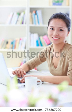 young asian businesswoman using laptop smile at camera in office